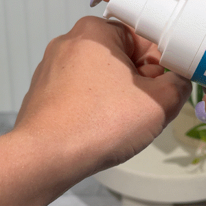 MooGoo Blemish Calming Cream being swatched on a hand to show the white, hydrating and light non-comedogenic formula, texture and consistency.