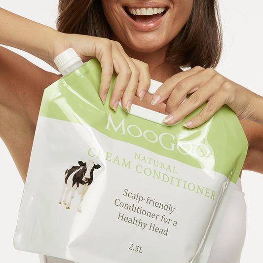 MooGoo Natural Cream Conditioner refill pouch 2.5L held by smiling woman, scalp friendly silicone free conditioner eco pack with 80% less plastic
