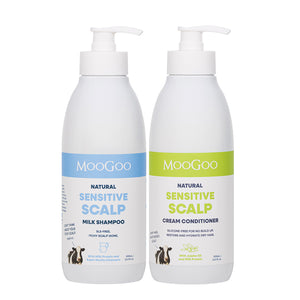 Two white pump bottles of MooGoo Natural Sensitive Scalp Hair Care products on a white background: Milk Shampoo with a blue label and Cream Conditioner with a green label. MooGoo Scalp-Friendly Milk Shampoo and Cream Conditioner, natural scalp care duo for dry, flaky, irritated skin.