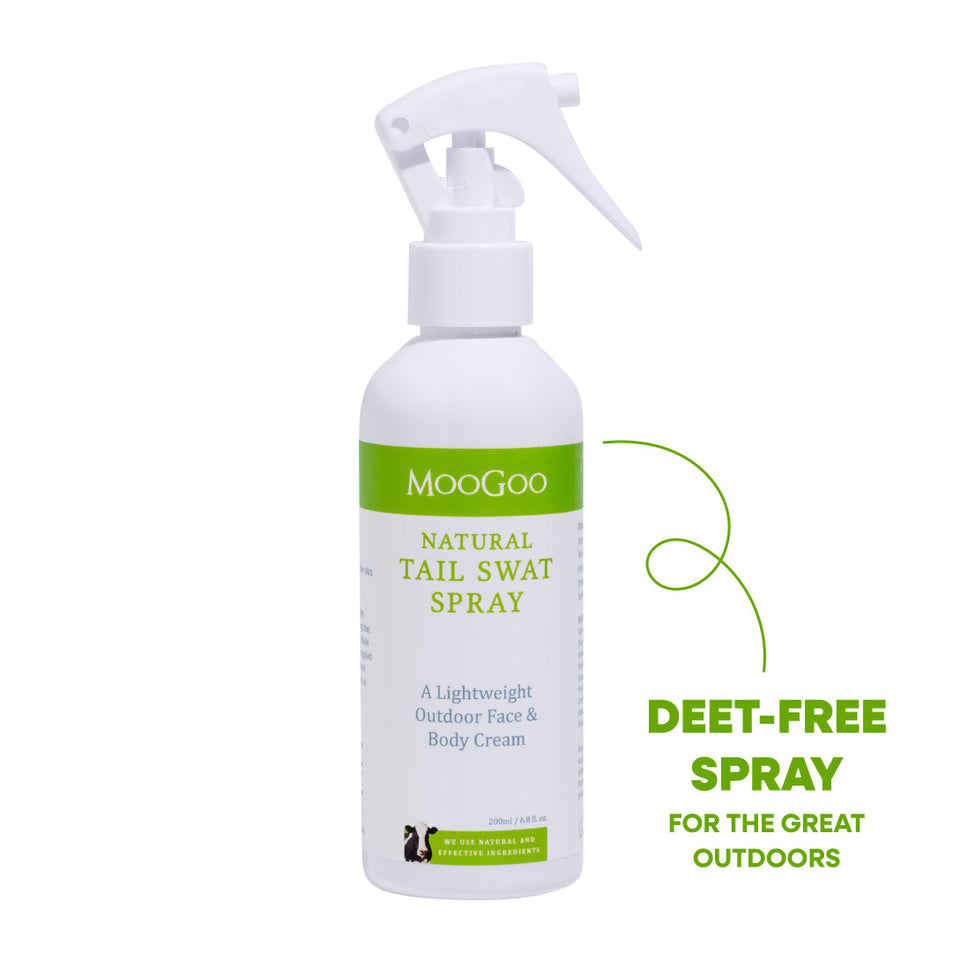 A white spray bottle of MooGoo Natural Tail Swat Spray with a green label, shown on a white background. DEET-Free gentle moisturizing body spray with hops extract, ideal for outdoor activities and sensitive skin types.